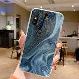 a person holding up a phone case with a blue and gold marble pattern