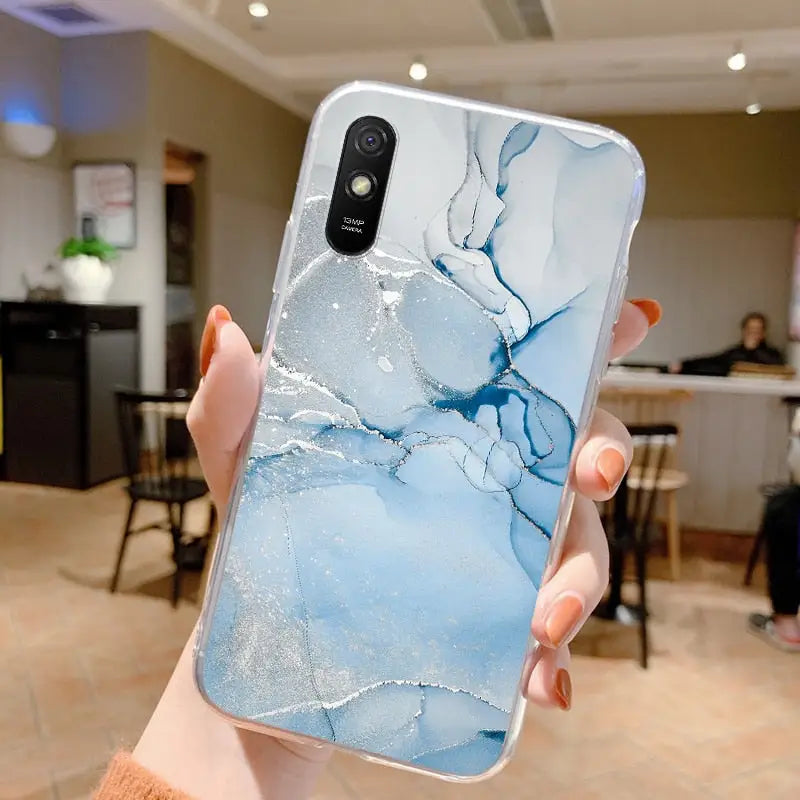 a person holding a phone with a blue marble pattern