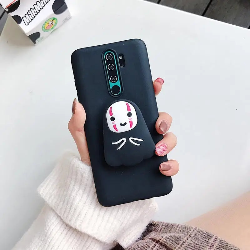 a woman holding a phone case with a face painted on it