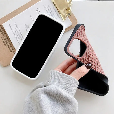 a person holding a phone case with a phone in the background