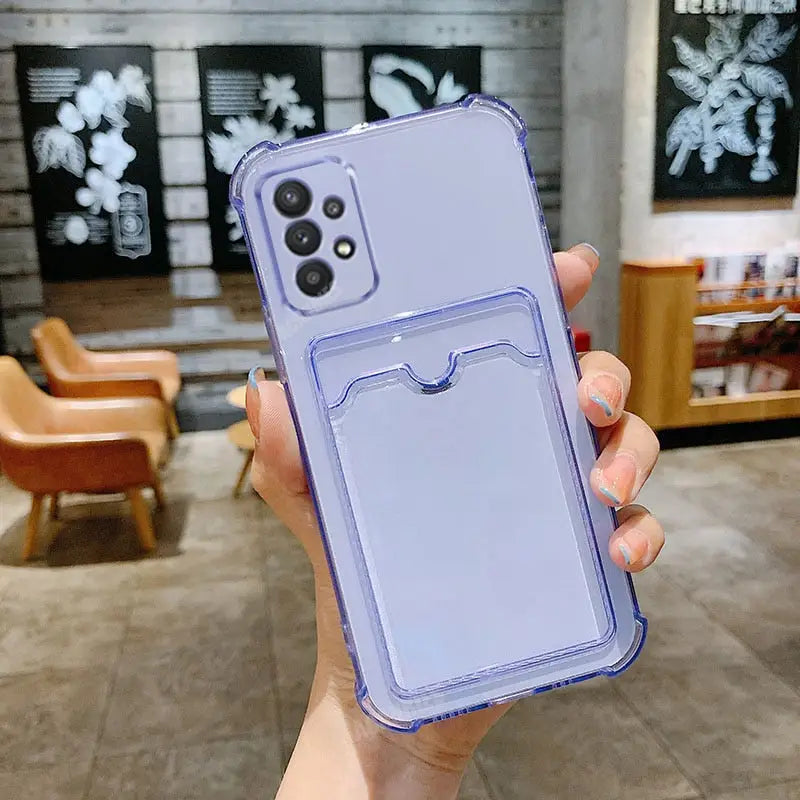 a hand holding a phone case with a blue phone in the background