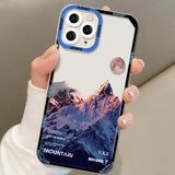a person holding a phone case with a mountain scene