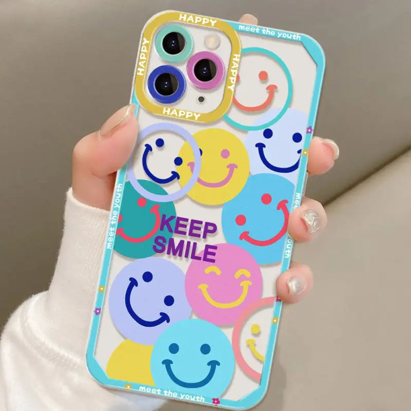 a woman holding a phone case with smiley faces