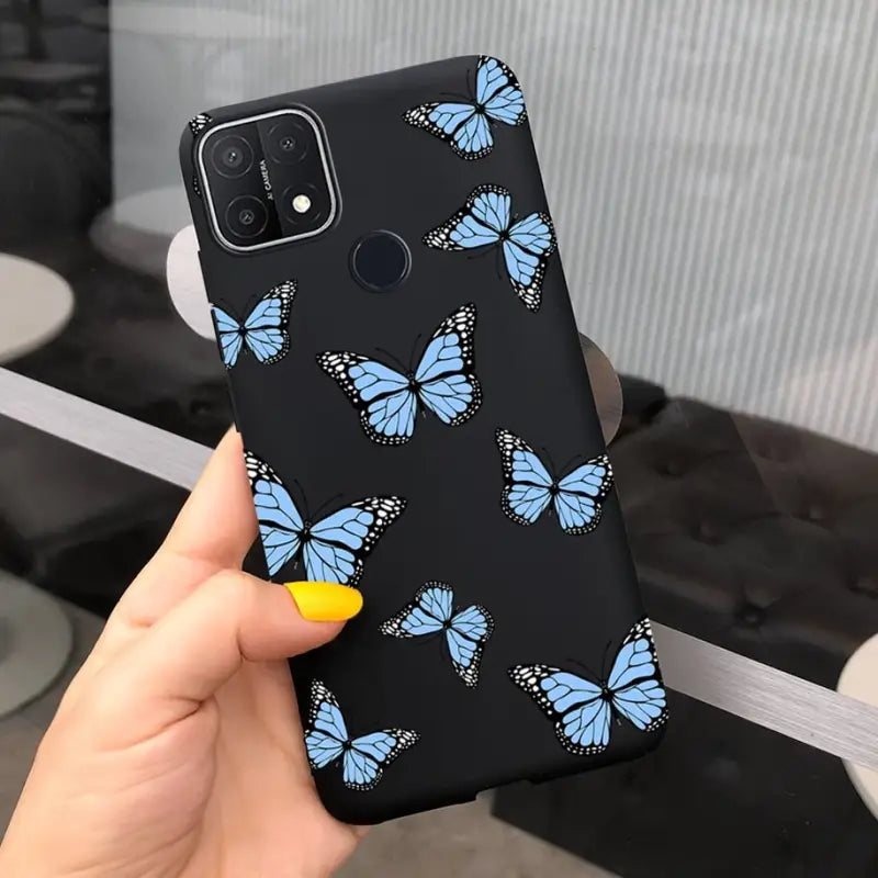 a hand holding a phone case with blue butterflies on it