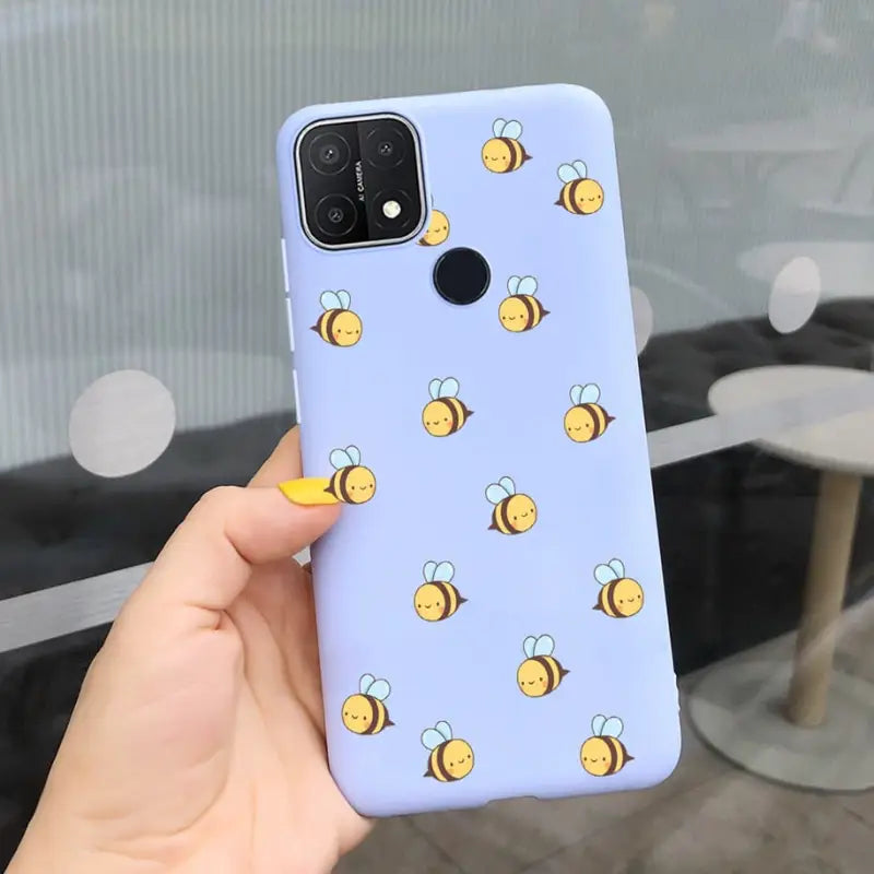 a hand holding a phone case with a bee pattern