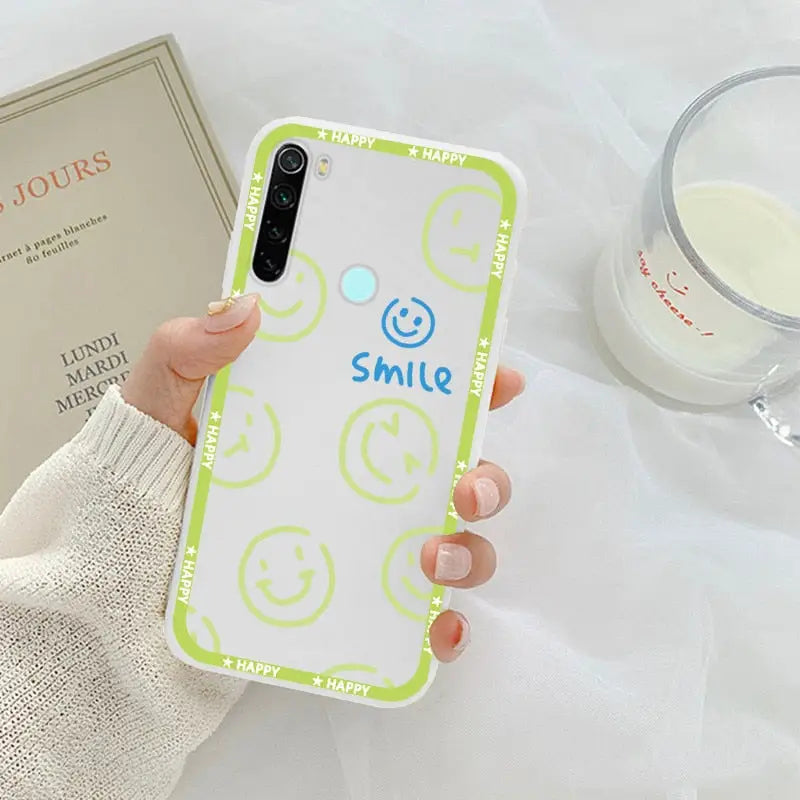 a person holding a phone case with smiley face