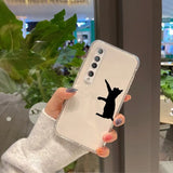 a woman holding up a phone case with a cat silhouette