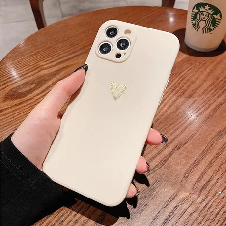 a woman holding a phone case with a heart on it