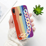 a person holding a phone case with a rainbow colored chain