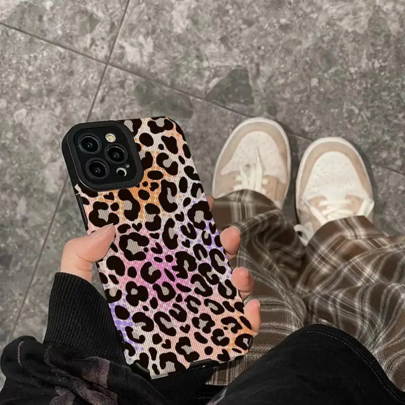 a person holding a phone case with a leopard print