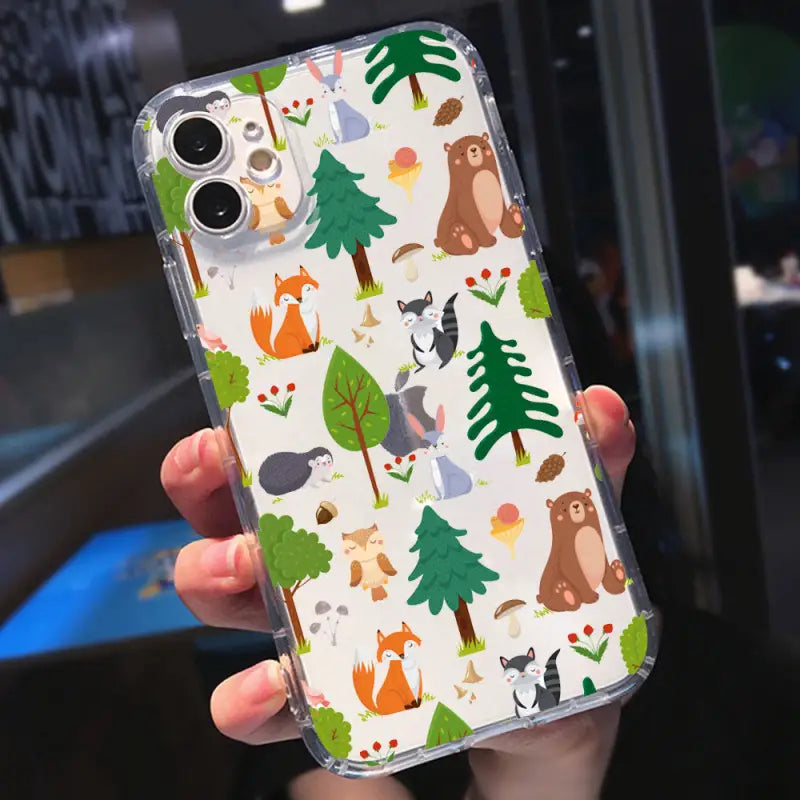 a person holding a phone case with a forest pattern