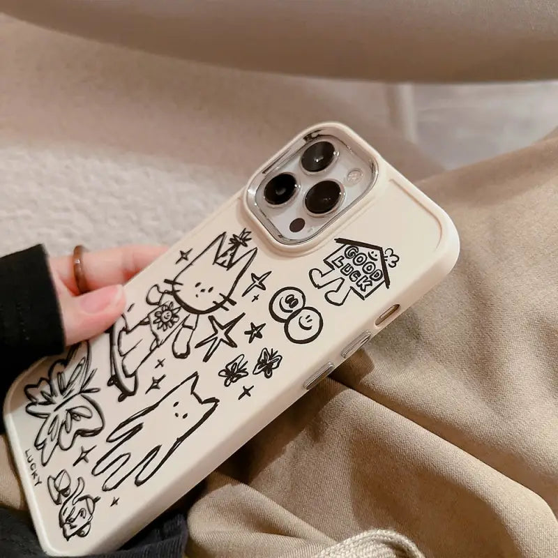 a woman holding a phone case with graffiti drawings on it