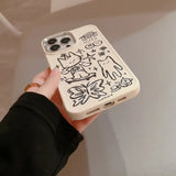 a person holding a phone case with graffiti drawings on it
