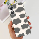 a woman holding a phone case with a cow print