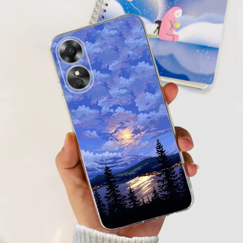 a person holding a phone case with a painting of a sunset