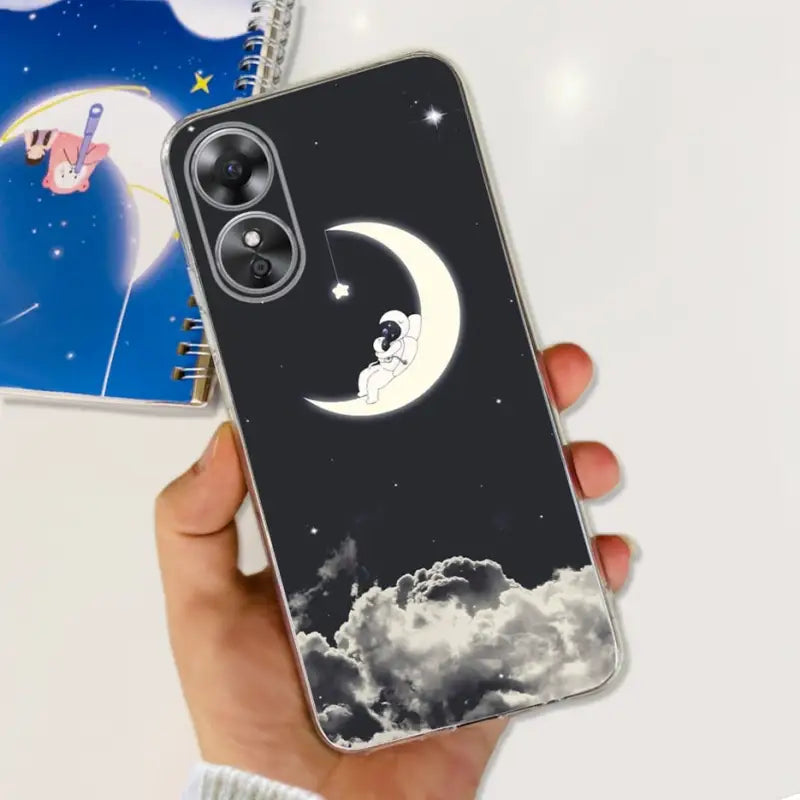 a hand holding a phone case with a moon and stars in the sky