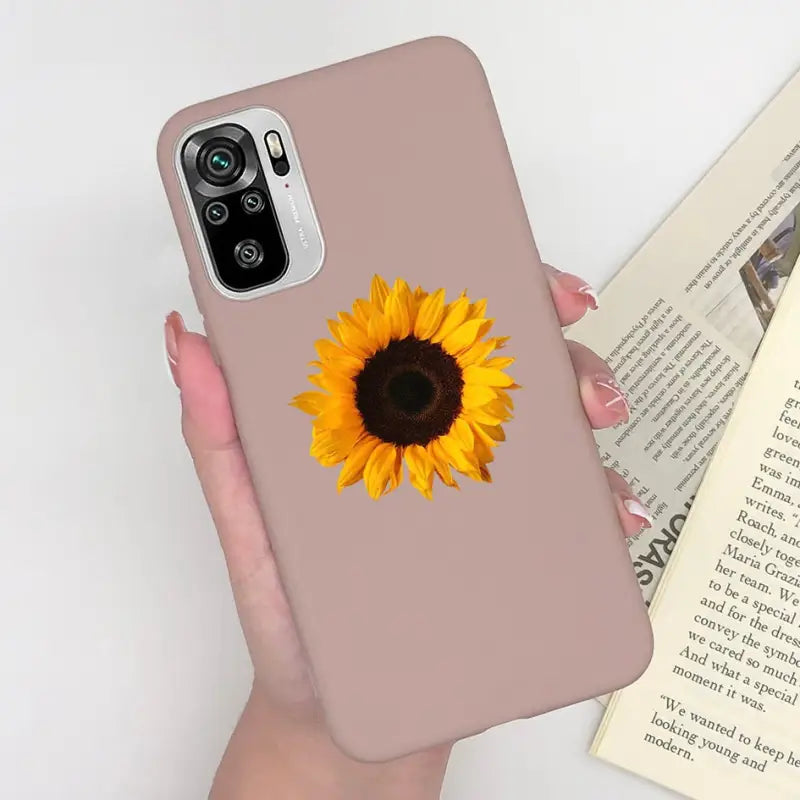 a woman holding a phone case with a sunflower on it