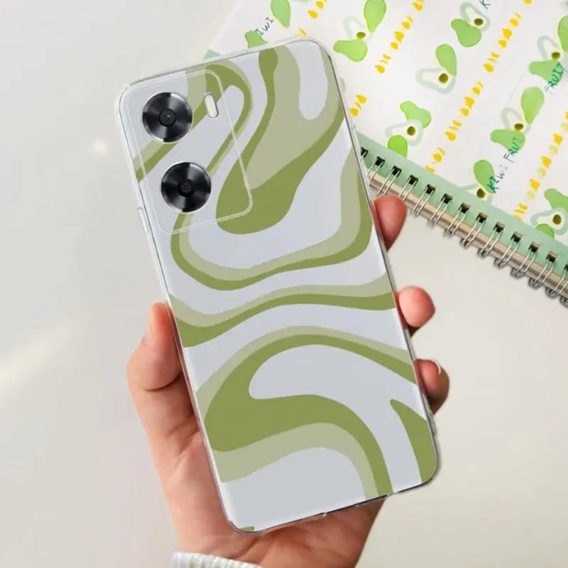 a person holding a phone case with a green and white pattern