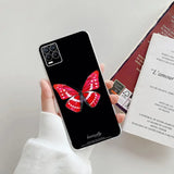 a woman holding a phone case with a red butterfly on it