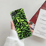 a person holding a phone case with a green leaf pattern