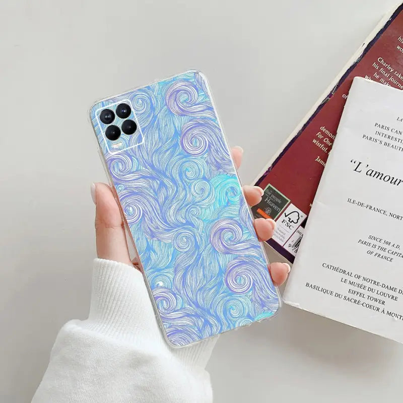 a person holding a phone case with a book in the background