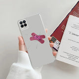a person holding a phone case with a pink heart on it