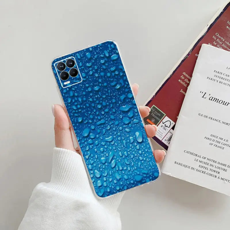 a person holding a phone case with water droplets on it