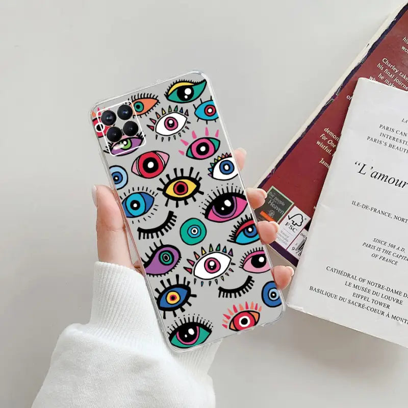 a person holding a phone case with an eye pattern