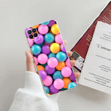 a person holding a phone case with colorful balls