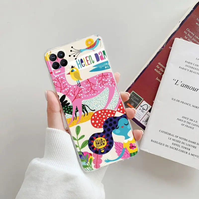 a person holding a phone case with a book