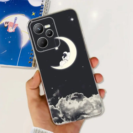 a hand holding a phone case with a moon and stars in the sky