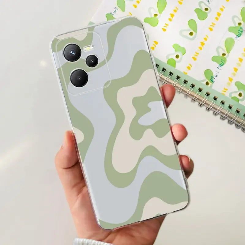 a person holding a phone case with a camouflage pattern