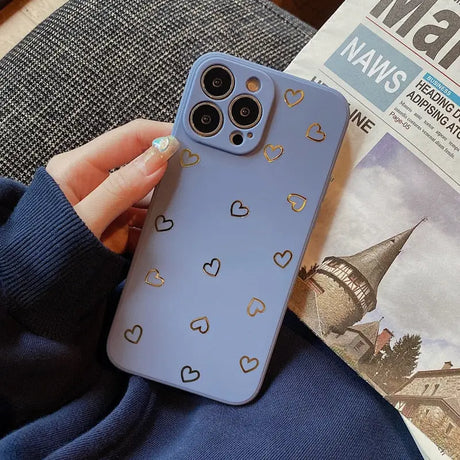 a woman holding a phone case with a heart pattern