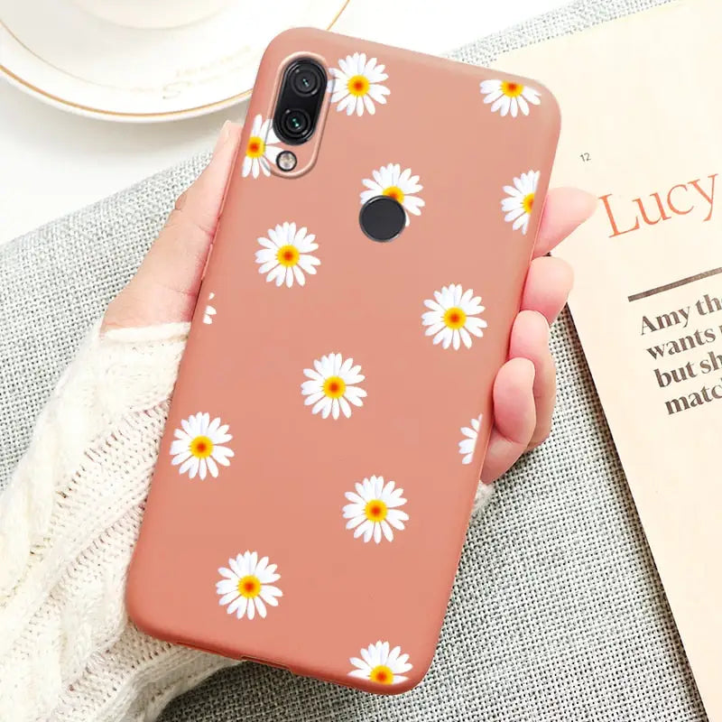 a close up of a person holding a phone with a flower pattern on it