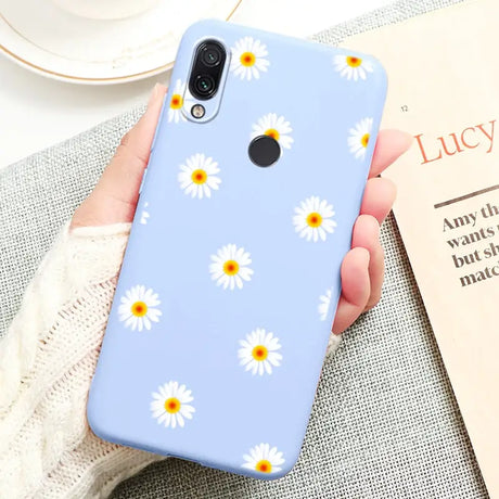 a close up of a person holding a phone with a flower pattern on it