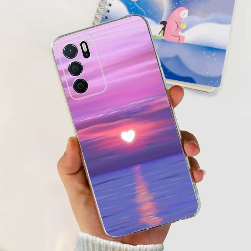 a person holding a phone with a sunset in the background