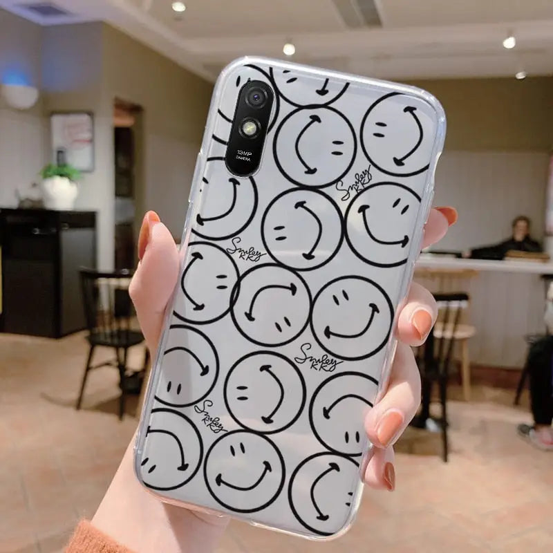 a woman holding up a phone case with smiley faces