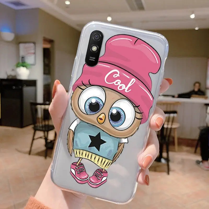 a person holding a phone case with an owl wearing a baseball cap