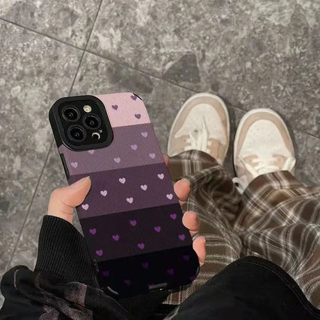 a person holding a phone case with hearts on it