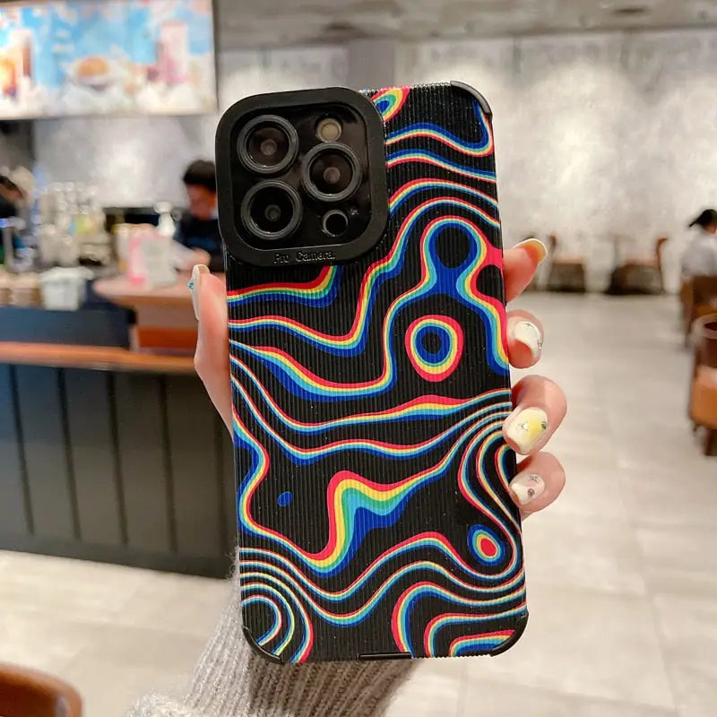 a person holding up a phone case with a colorful swirl design