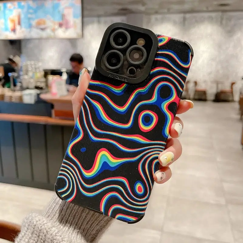 a hand holding a phone case with a colorful swirl design