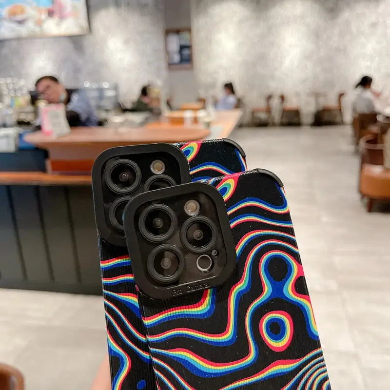 a person holding up a phone case with a colorful pattern