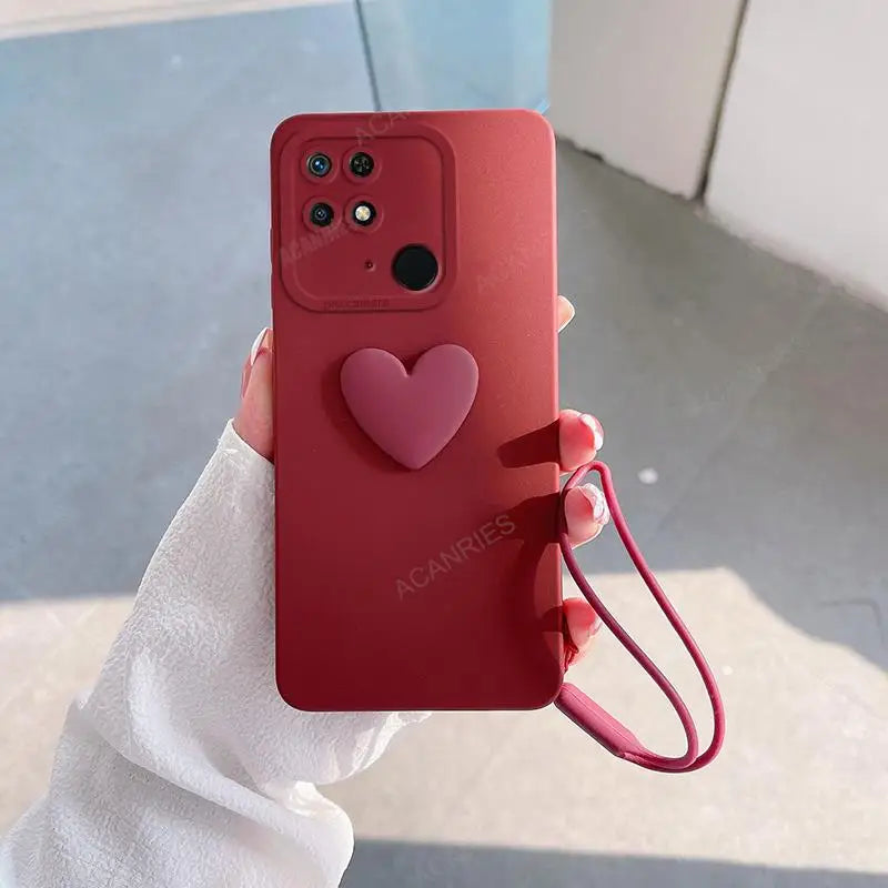 a person holding a red phone case with a heart on it