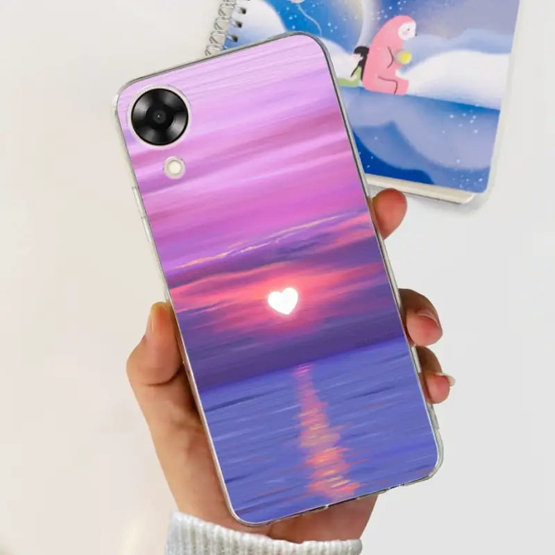 a person holding a phone case with a sunset in the background