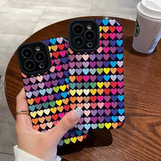 a person holding up a phone case with hearts on it
