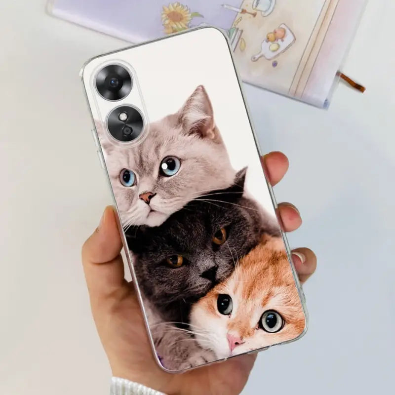a person holding a phone case with two cats