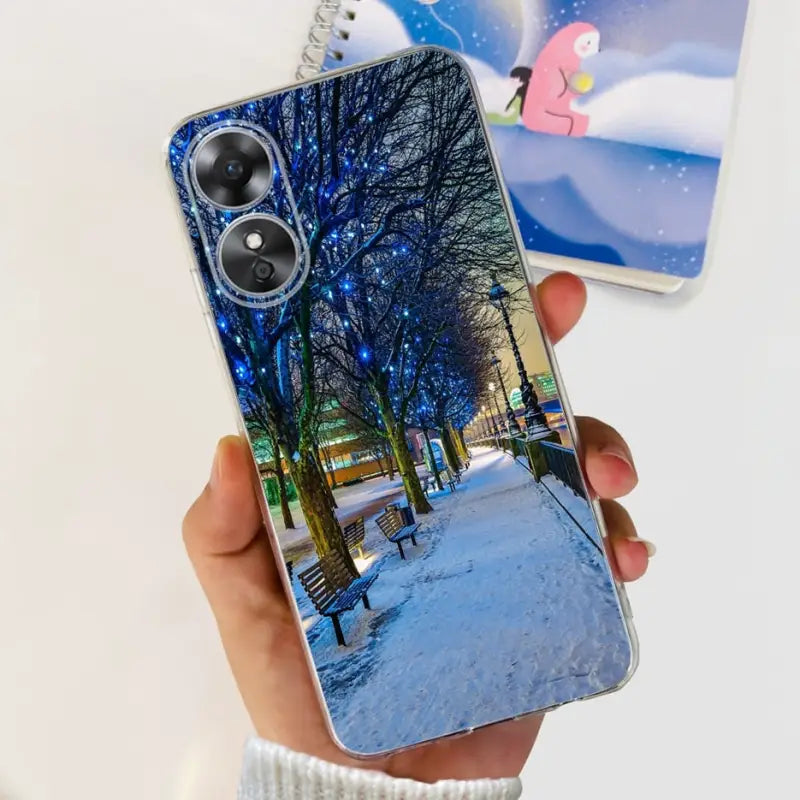 a person holding a phone case with a photo of a snowy scene