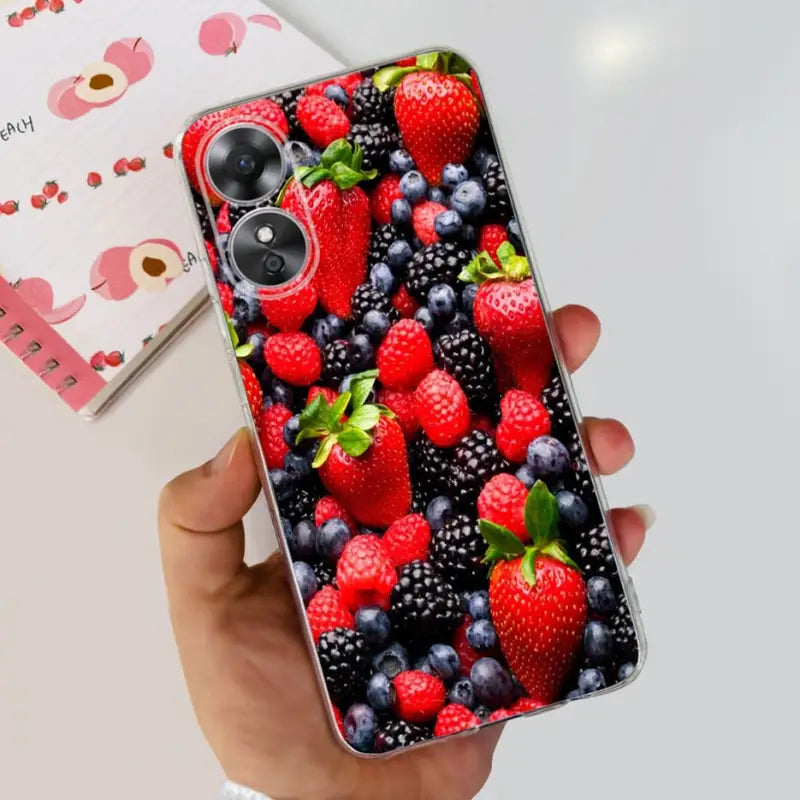 a person holding a phone case with berries and berries on it