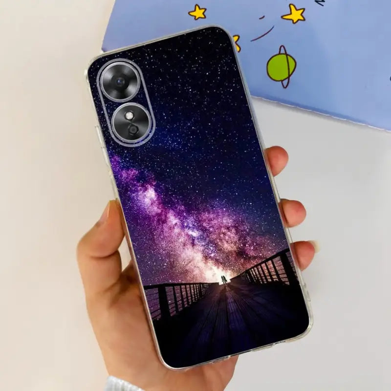 a hand holding a phone case with a starr sky in the background