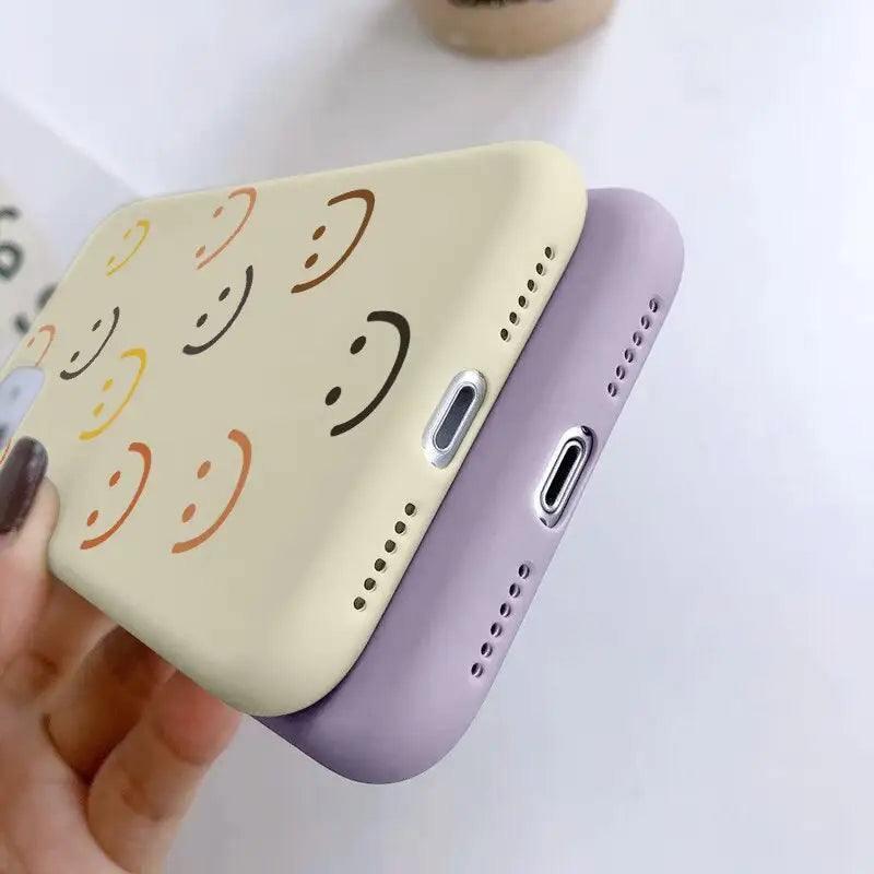 a person holding a phone case with a smiley face on it